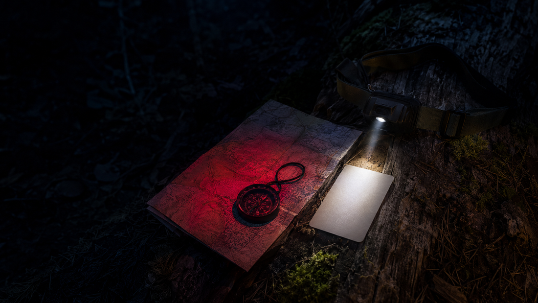Compact headlamp showing red and white modes beside a night map