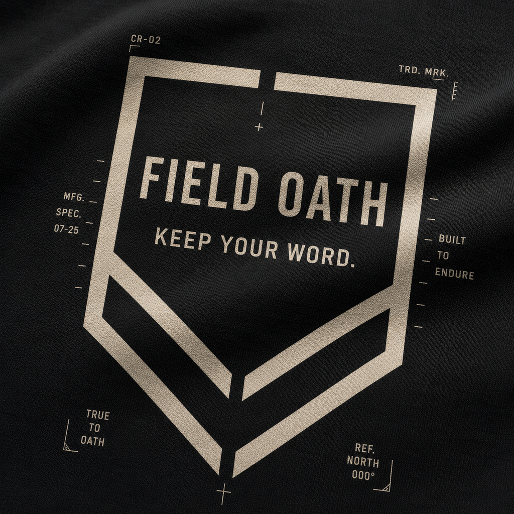Close-up of FIELD OATH Crest Line T-Shirt shield print, connected chevrons and technical typography