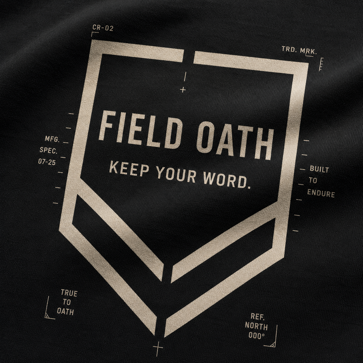 Close-up of FIELD OATH Crest Line T-Shirt shield print, connected chevrons and technical typography