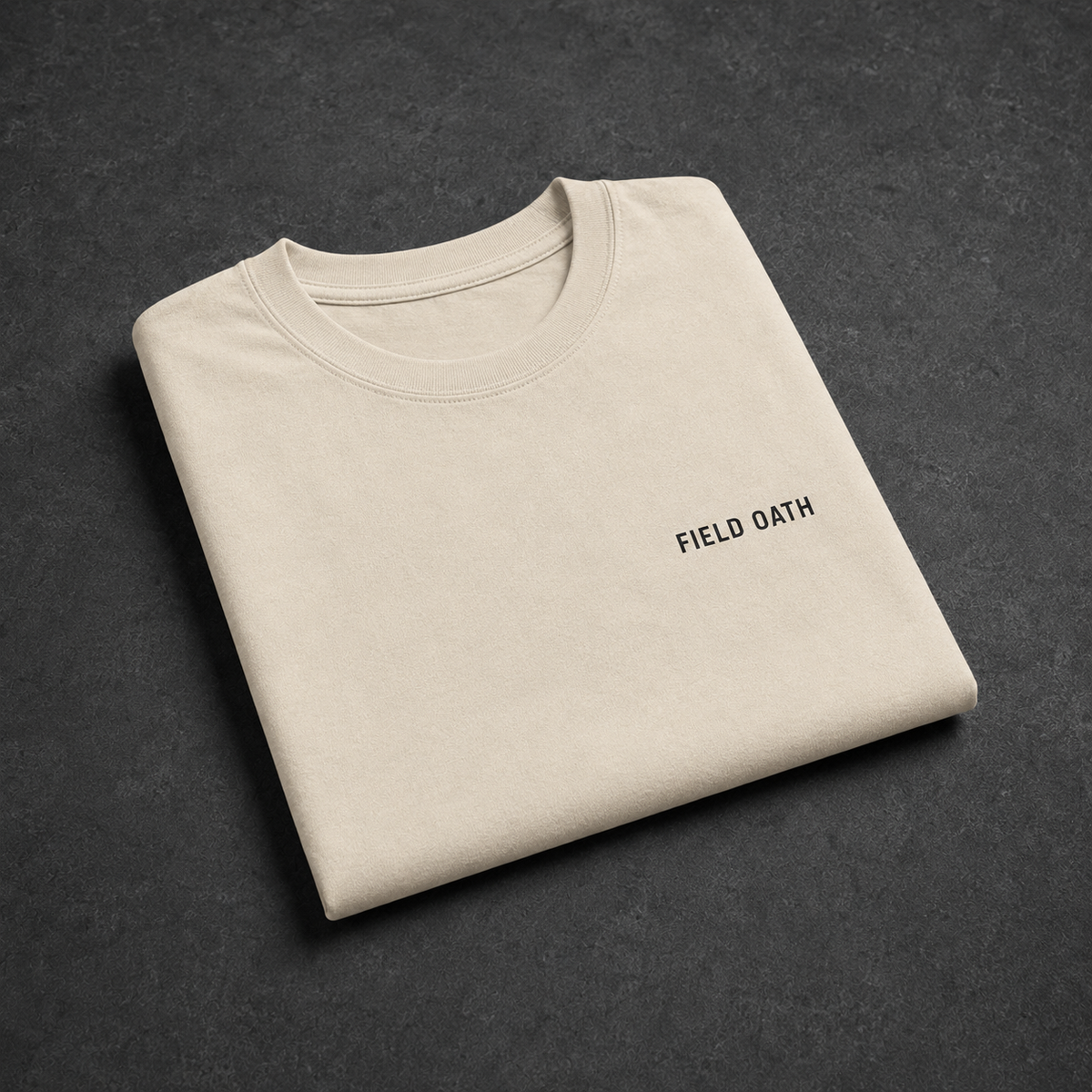 Bone FIELD OATH Field Standard T-Shirt folded on a dark graphite studio table