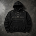 FIELD OATH Under Load Watch Hoodie black hoodie front artwork on dark concrete