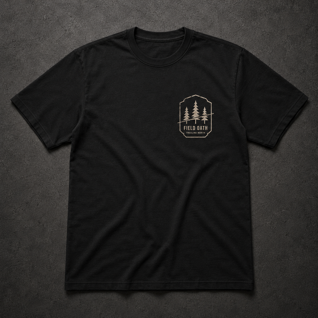 Black FIELD OATH Treeline North T-Shirt front flat lay with pine bearing left-chest artwork