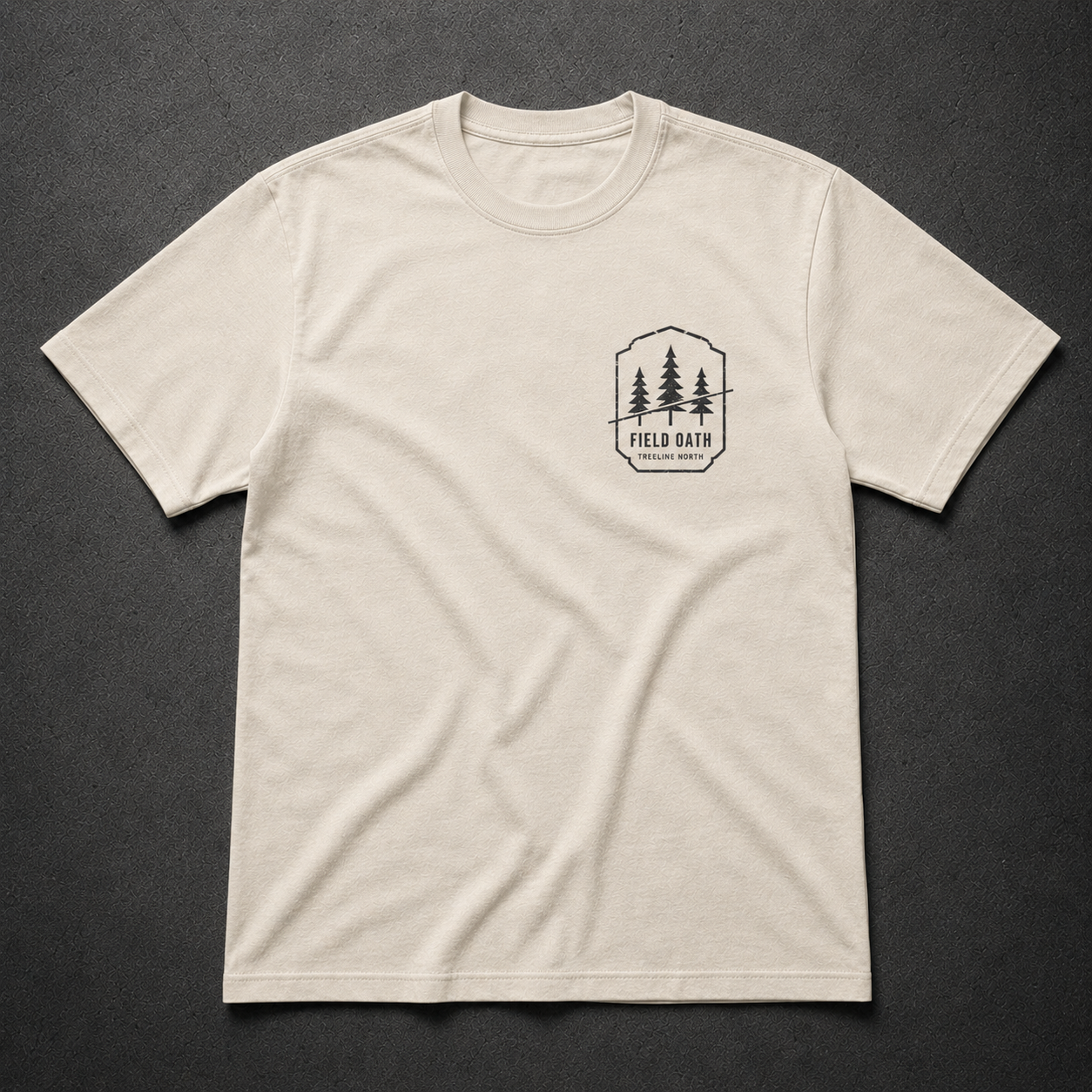 Bone FIELD OATH Treeline North T-Shirt front flat lay with matching pine bearing left-chest artwork